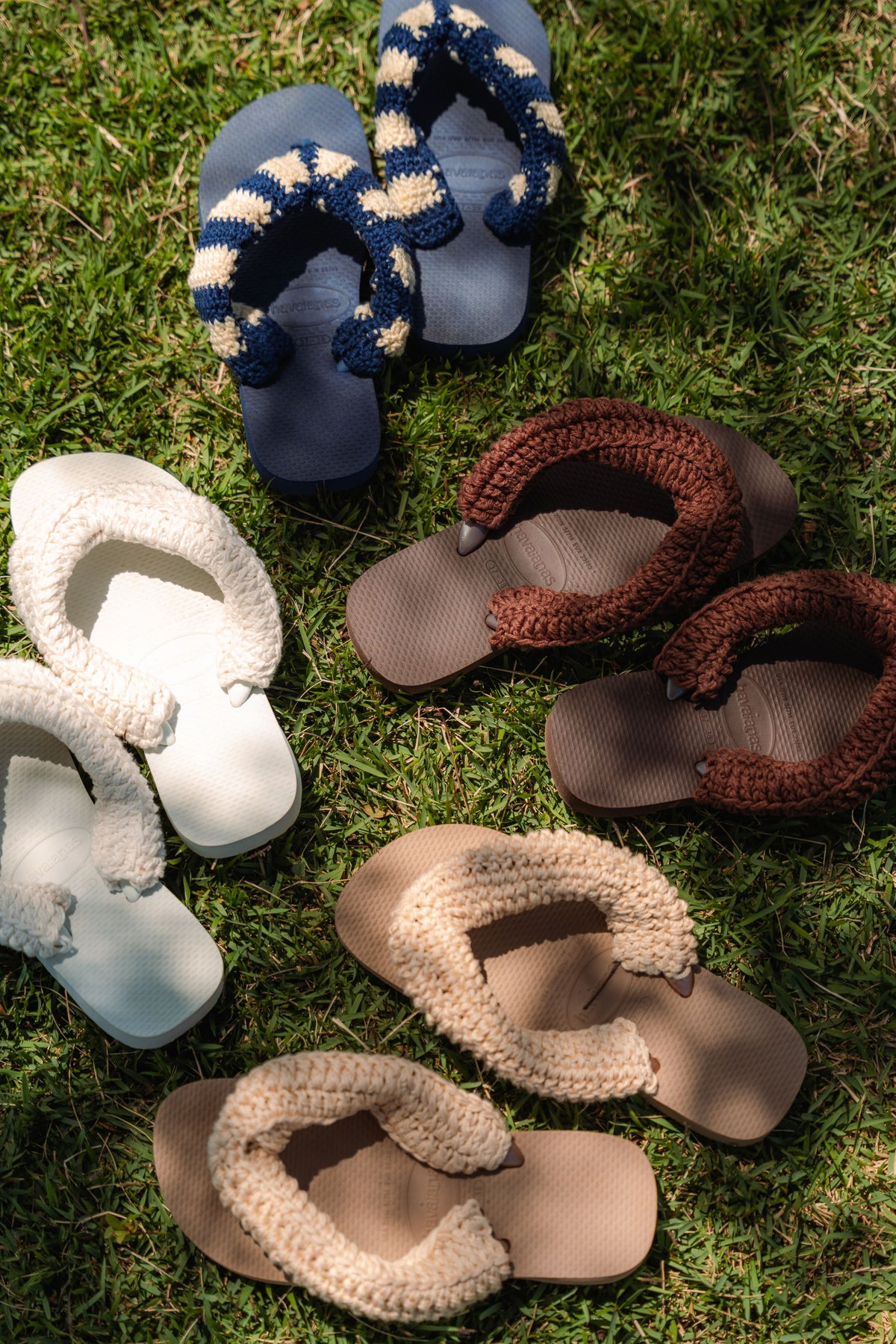 Havaianas com tiras de crochê da Satú em off white, bege, marrom e azul marinho sobre a grama