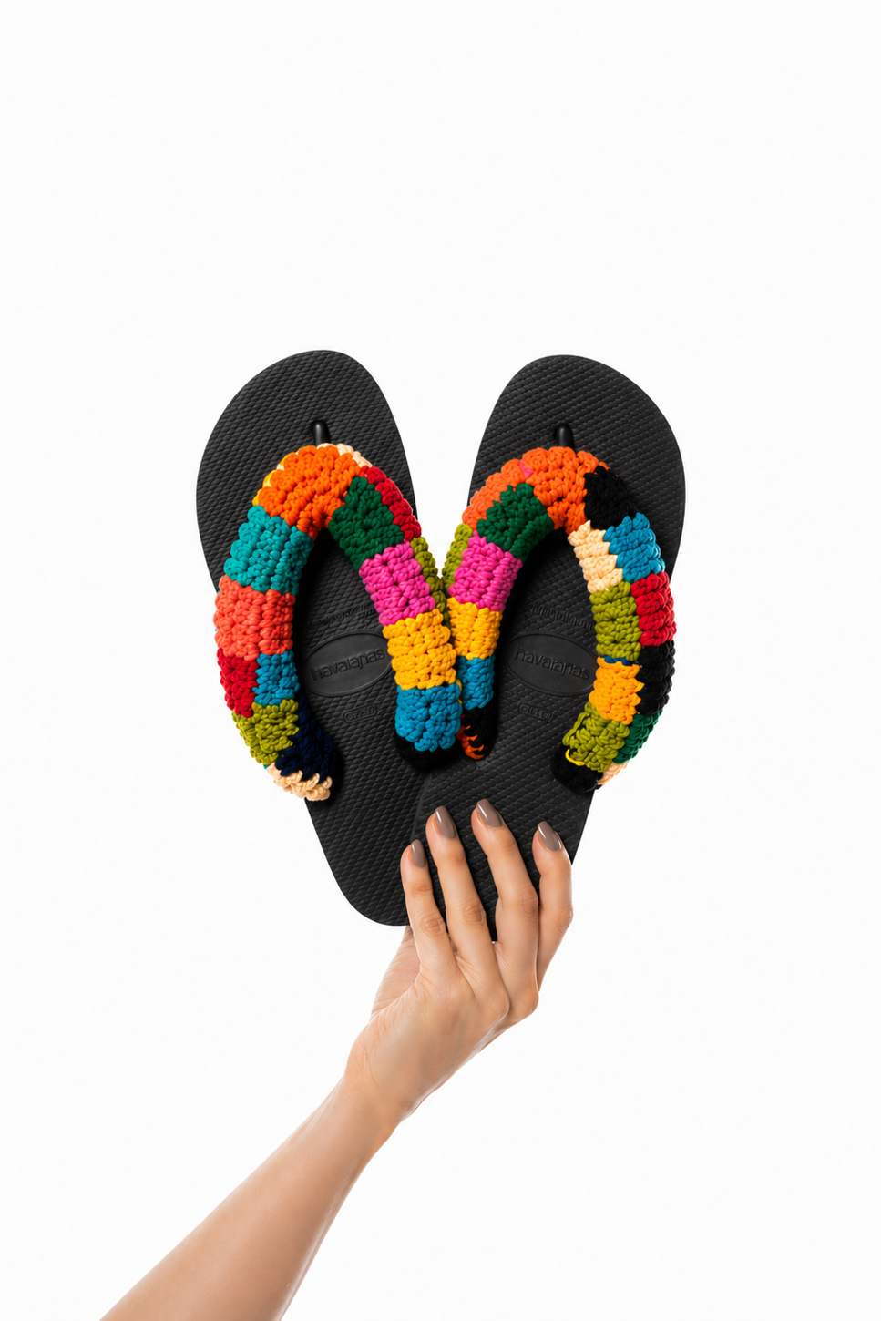 Havaianas Tiê preta com tiras de crochê colorido em patchwork, segurada na mão