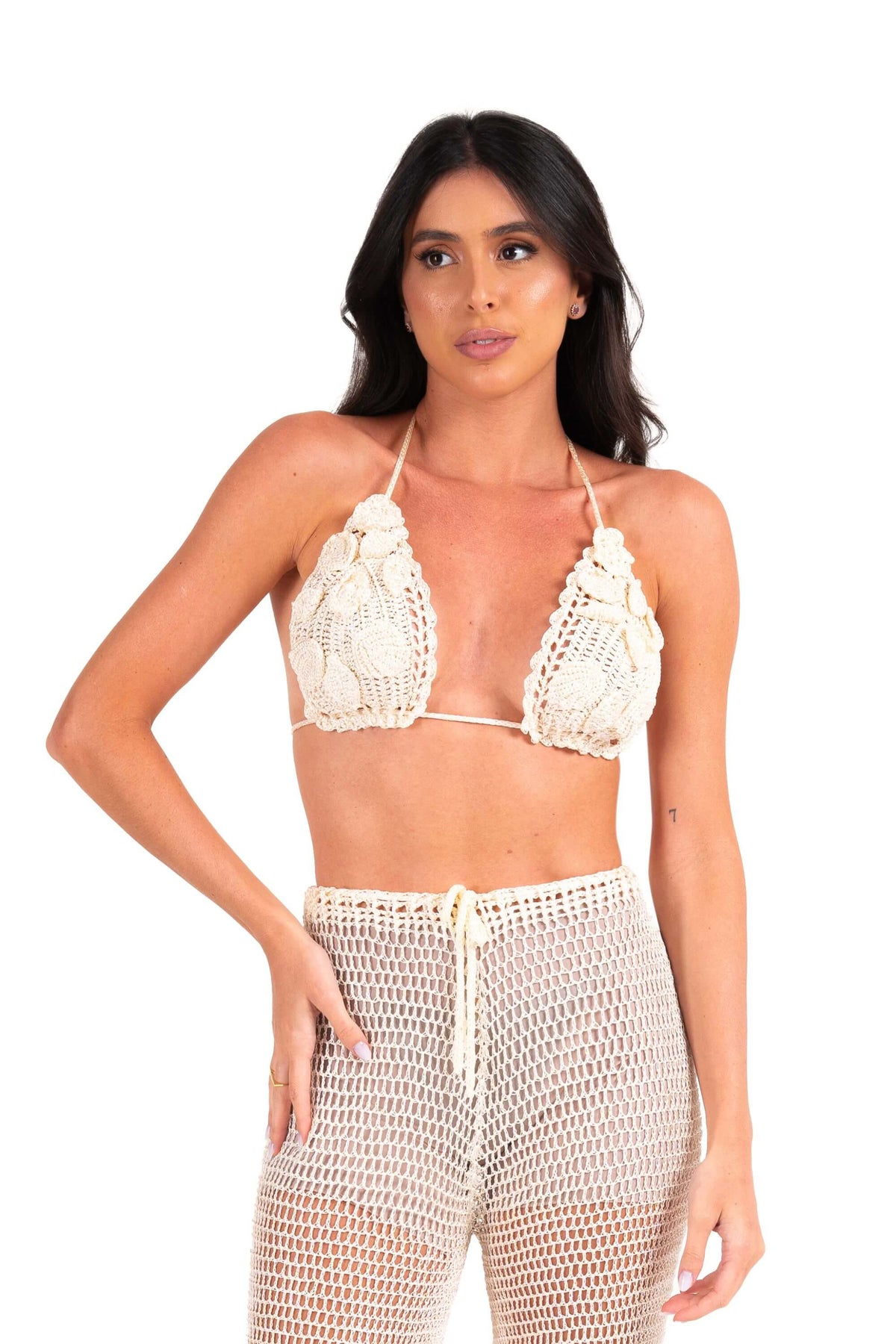Top Alika off white de crochê com flores em alto relevo, usado com calça de crochê